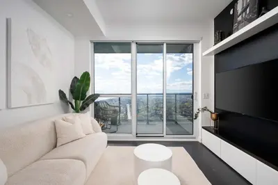 a living room with a couch and a large window at Elegant Sunset Lake View Suite with Parking in Toronto