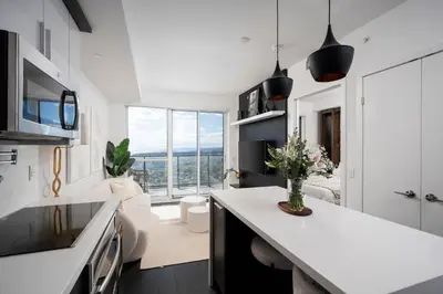 a kitchen and living room with a large window at Elegant Sunset Lake View Suite with Parking in Toronto