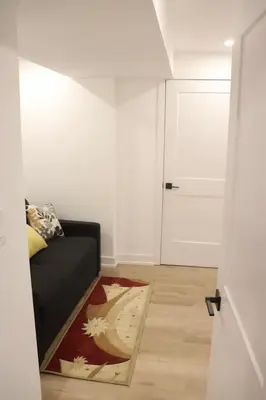a living room with a black couch and a white door at Luxury Brand-New Spacious Apartment in Richmond Hill in Richmond Hill