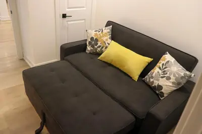 a black couch with pillows on it in a room at Luxury Brand-New Spacious Apartment in Richmond Hill in Richmond Hill