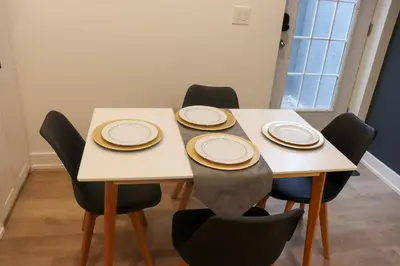 a table with chairs and plates on top of it at Luxury Brand-New Spacious Apartment in Richmond Hill in Richmond Hill