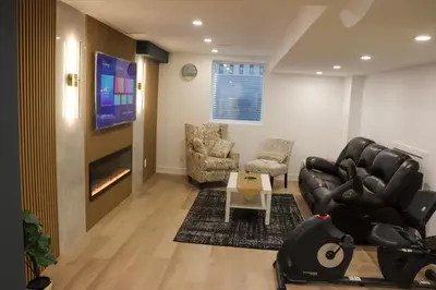 a living room with a couch and chairs and a tv at Luxury Brand-New Spacious Apartment in Richmond Hill in Richmond Hill