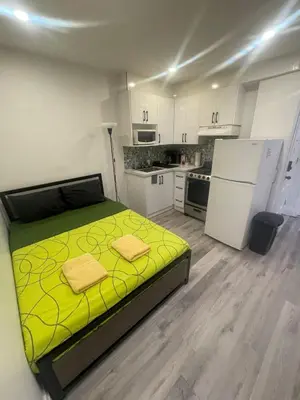 a bedroom with a yellow bed in a kitchen at Toronto Downtown Holiday Home-Private Patio,Free Wifi & Self Checkin in Toronto