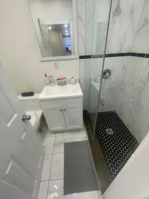 a white bathroom with a shower and a sink at Toronto Downtown Holiday Home-Private Patio,Free Wifi & Self Checkin in Toronto