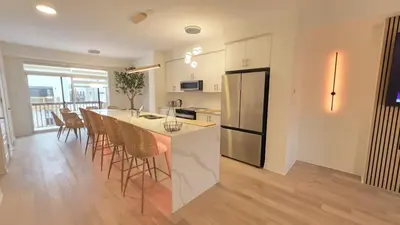 a kitchen and dining room with a counter and a refrigerator at Nordic Three Brantford in Brantford