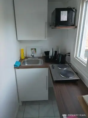 a small kitchen with a sink and a microwave at Midtown Toronto studio in Toronto