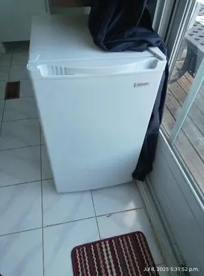 a white refrigerator sitting in a kitchen next to a door at Midtown Toronto studio in Toronto