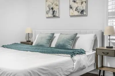 a bedroom with a white bed with blue pillows at Romeo & Juliet Niagara Retreat - Clifton Hill in Niagara Falls