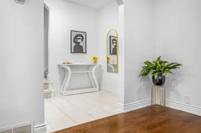 a white bathroom with a sink and a vase on the floor at Romeo & Juliet Niagara Retreat - Clifton Hill in Niagara Falls