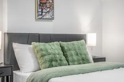a bed with green and white pillows on it at Romeo & Juliet Niagara Retreat - Clifton Hill in Niagara Falls