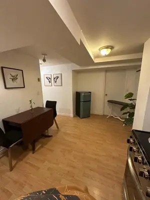 a living room with a table and a kitchen at 1 Bedroom Apartment Owen Sound in Owen Sound