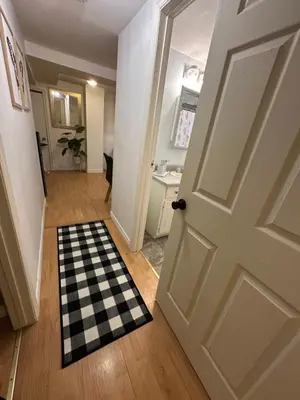 a door leading into a hallway with a checkered rug at 1 Bedroom Apartment Owen Sound in Owen Sound