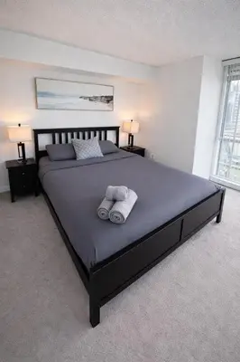 a bedroom with a large bed with two towels on it at Fully furnished Lux 1bedroom condo in Toronto