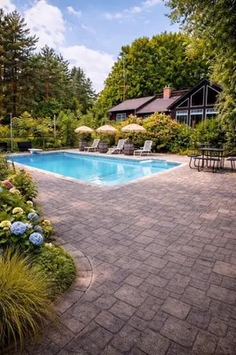 a swimming pool with chairs and umbrellas in a yard at Peaceful Forest Retreat with Fire Pit and BBQ near Mansfield Ski Club in Mulmur