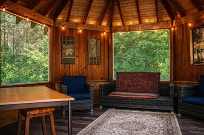 a screened in porch with two chairs and a table at Peaceful Forest Retreat with Fire Pit and BBQ near Mansfield Ski Club in Mulmur