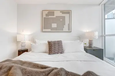 a bedroom with a white bed with a blanket at 40th Fl Designer Lakeview 2BR PATH & Union Access in Toronto
