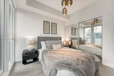 a bedroom with two beds and a mirror at 40th Fl Designer Lakeview 2BR PATH & Union Access in Toronto