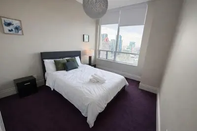 a bedroom with a bed and a large window at Luxury Penthouse with Celebration Square Views in Mississauga