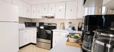a kitchen with white cabinets and black appliances at Luxury 3BR Near Pearson Airport Free Parking in Toronto