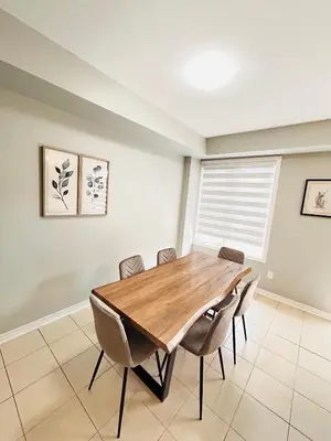 a dining room with a wooden table and chairs at Luxury home Netflix & parking promo price with 7beds in Brampton