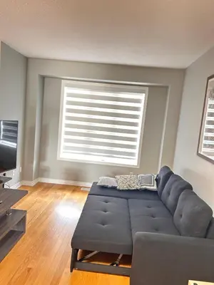 a living room with a couch and a large window at Luxury home Netflix & parking promo price with 7beds in Brampton