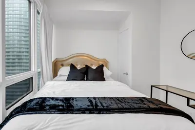 a bedroom with a large bed with a window at Luxe 3-Bedroom Lakeview Condo, Free parking ,Walk to CN Tower, Scotiabank Arena & Rogers Centre in Toronto