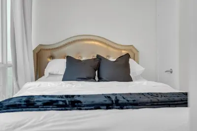 a bedroom with a bed with blue and white pillows at Luxe 3-Bedroom Lakeview Condo, Free parking ,Walk to CN Tower, Scotiabank Arena & Rogers Centre in Toronto