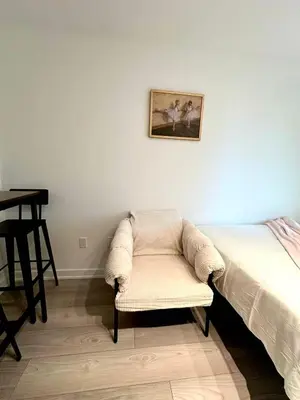 a bedroom with a chair next to a bed at Cozy studio near Yonge Eglinton Subway Midtown in Toronto