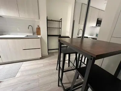 a kitchen with a wooden table and chairs in it at Cozy studio near Yonge Eglinton Subway Midtown in Toronto