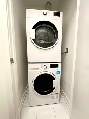 a washing machine and a dryer in a room at Cozy studio near Yonge Eglinton Subway Midtown in Toronto