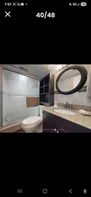 a bathroom with a toilet and a sink and a mirror at Cozy home in Toronto