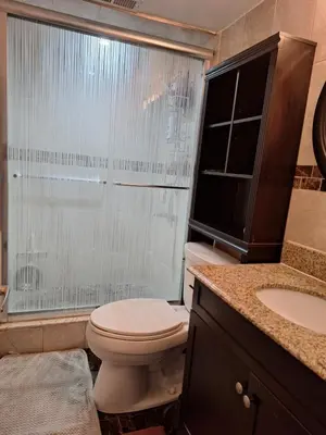a bathroom with a toilet and a shower and a sink at Cozy home in Toronto