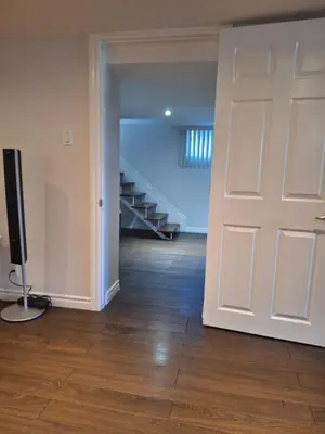 an empty room with a door and a television at Cozy home in Toronto