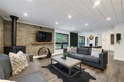 a living room with a couch and a fireplace at Evergreen Escape - 3 Acres, Hot Tub, Volleyball Court in Collingwood