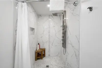 a bathroom with a shower with a shower curtain at Evergreen Escape - 3 Acres, Hot Tub, Volleyball Court in Collingwood