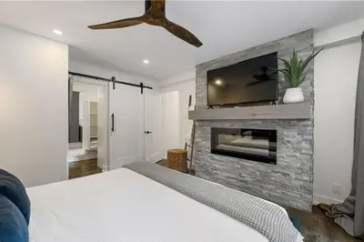 a bedroom with a fireplace with a tv above it at Evergreen Escape - 3 Acres, Hot Tub, Volleyball Court in Collingwood
