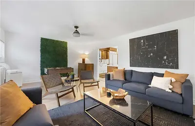 a living room with a blue couch and a table at Evergreen Escape - 3 Acres, Hot Tub, Volleyball Court in Collingwood