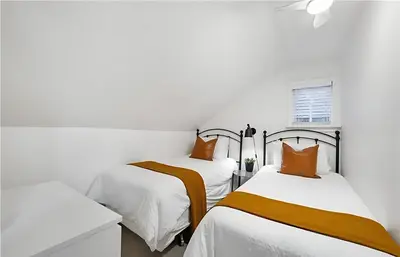 two beds in a room with white walls and orange pillows at Evergreen Escape - 3 Acres, Hot Tub, Volleyball Court in Collingwood