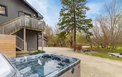 a bath tub in front of a house at Evergreen Escape - 3 Acres, Hot Tub, Volleyball Court in Collingwood