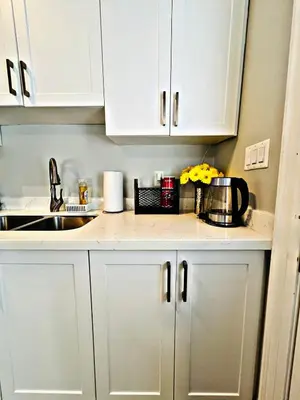 a kitchen counter with white cabinets and a sink at Cozy Place in Oshawa
