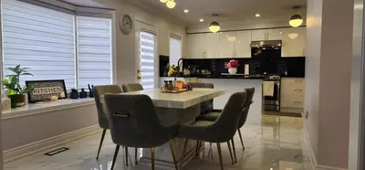 a kitchen with a table and chairs in a kitchen at Charming Room in Brampton