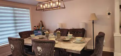 a dining room with a wooden table and chairs at Charming Room in Brampton