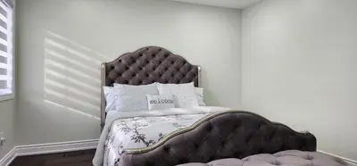 a bedroom with a bed with a metal frame at Charming Room in Brampton