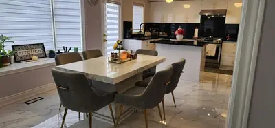 a kitchen with a large marble table and chairs at Lavish Bright Bedroom in Brampton