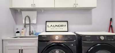 a kitchen with two washing machines and a sink at Lavish Bright Bedroom in Brampton