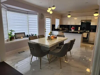 a kitchen with a table and chairs in a kitchen at Lavish Bright Bedroom in Brampton