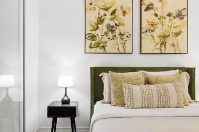 a bedroom with a bed with two paintings on the wall at Spacious Condo with 2 Beds Unbeatable Location in Toronto