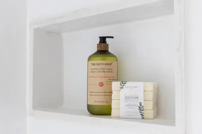 a bottle of soap and a box on a shelf at New Modern Home in Old Town in Niagara on the Lake