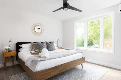 a bedroom with a large bed with a ceiling fan at New Modern Home in Old Town in Niagara on the Lake