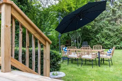 a table and chairs with an umbrella on a deck at New Modern Home in Old Town in Niagara on the Lake